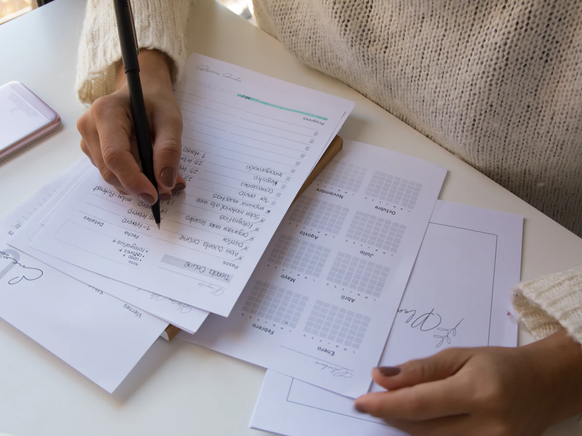 A teacher filling in paper forms by hand at a desk.