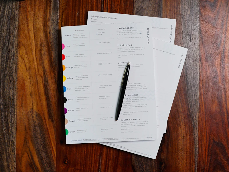 Printed pages and a pen on a wooden table.